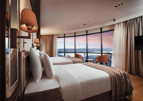 una camera d'albergo con due letti e una grande finestra di The Hotels, Galata a Istanbul