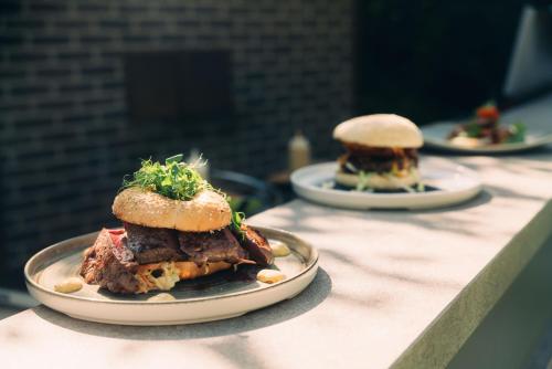 two plates of food on a counter with a sandwich at Cortisen am See - Adults only in St. Wolfgang