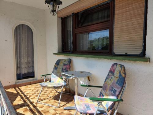 two chairs sitting on a porch under a window at Retro Retreat Izačić in Bihać
