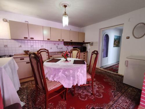 a kitchen with a table with a white table cloth at Retro Retreat Izačić in Bihać