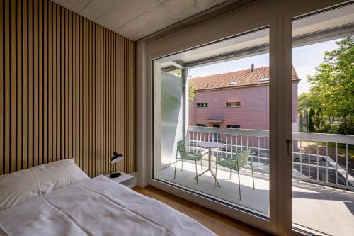 a bedroom with a bed and a large window at Aparthotel Il Momento Bern Expo - Self Check-In Hotel in Bern