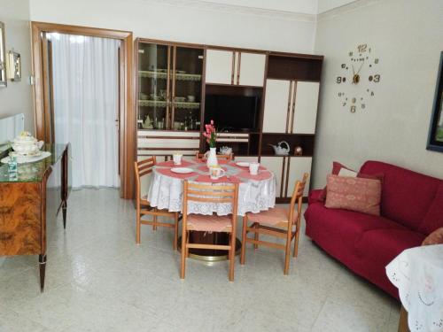 un salon avec une table et un canapé rouge dans l'établissement Casa vacanza Rosy, à Manfredonia