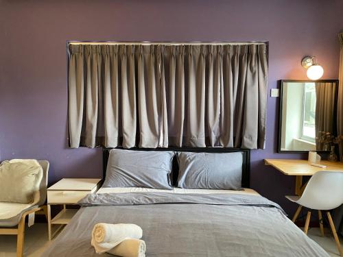 a bedroom with a bed and a window with curtains at Aurora Court Service Apartment in George Town