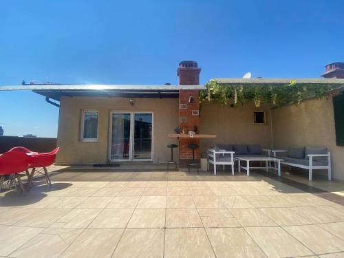 a patio with chairs and tables on top of a house at Siera's Penthouse in Pristina