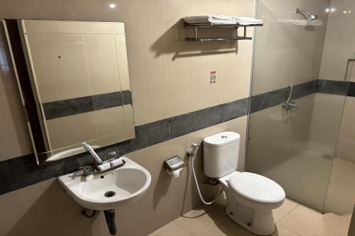 a bathroom with a toilet and a sink and a shower at Hotel Pesona Bamboe Lembang in Genteng