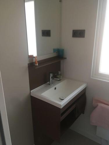 une salle de bain avec un lavabo blanc et un miroir dans l'établissement Bungalow Mobil Home Carry-le-rouet, à Carry-le-Rouet