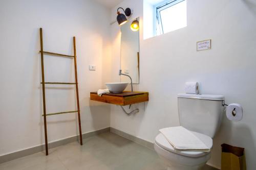 a bathroom with a white toilet and a sink at Vilarejo - Centro Histórico Ilhabela in Ilhabela
