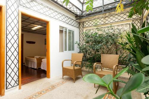 an open door to a patio with chairs and a table at Vilarejo - Centro Histórico Ilhabela in Ilhabela