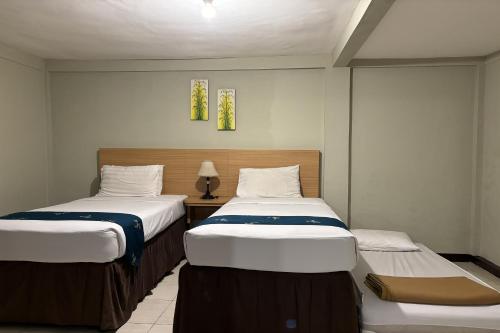 two twin beds in a room with at Hotel Pesona Bamboe Lembang in Genteng