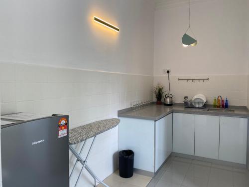 a white kitchen with a counter and a sink at Aurora Court Service Apartment in George Town