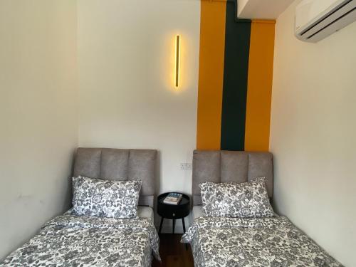 two beds sitting next to each other in a room at Aurora Court Service Apartment in George Town