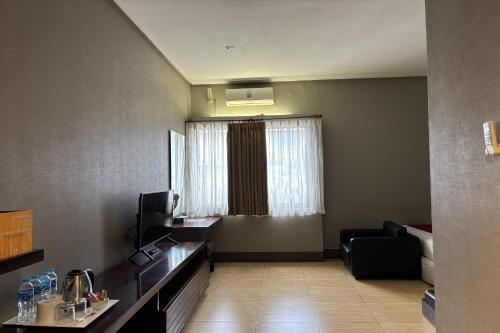 a hotel room with a table and a chair and a window at Hotel Pesona Bamboe Lembang in Genteng