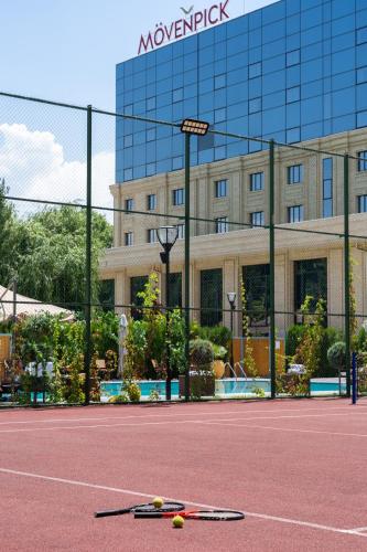 a tennis court in front of a building at Mövenpick Samarkand in Samarkand
