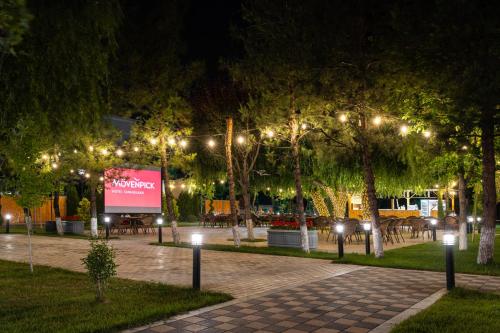 a park at night with lights and a billboard at Mövenpick Samarkand in Samarkand