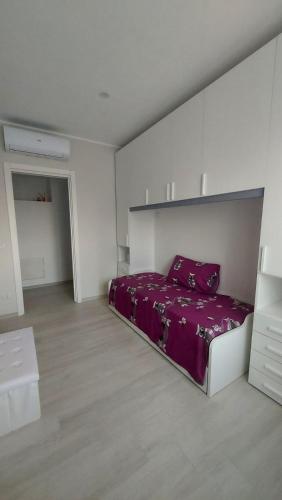 a bedroom with a purple bed in a white room at Home sweet Home in Montecalvo Irpino
