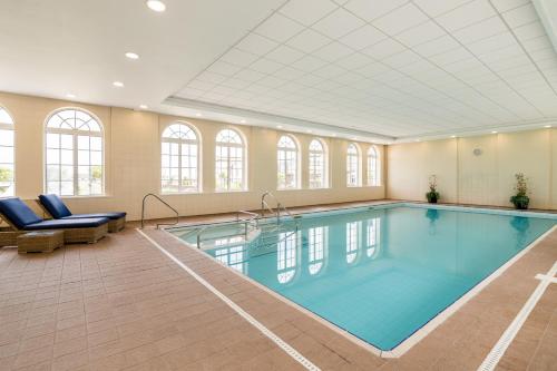 a large swimming pool in a large room with windows at The Palace Hotel in Paignton