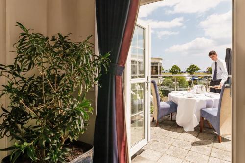 a man standing in front of a table on a balcony at The Palace Hotel in Paignton