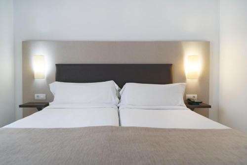 a bedroom with a bed with two white pillows at LABRANDA Bahía Fañabé & Villas in Adeje