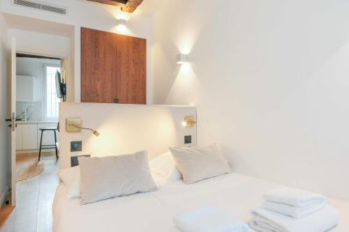 une chambre avec un lit blanc avec des oreillers blancs dans l'établissement Relaxing Urban Getaway, Notre Dame, à Paris