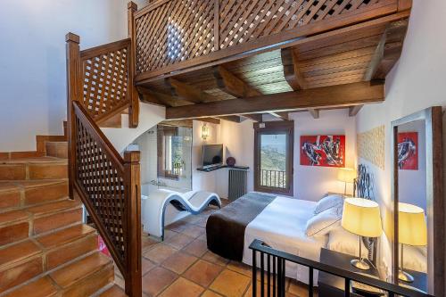 a bedroom with a bed and a staircase at Hotel Alahuar in Benimaurell