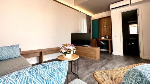 a living room with a couch and a tv at Caleta Dorada in Caleta De Fuste