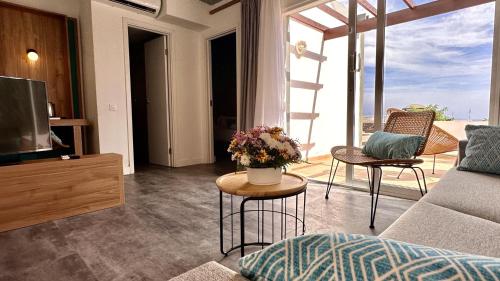 a living room with a couch and a table with flowers at Caleta Dorada in Caleta De Fuste