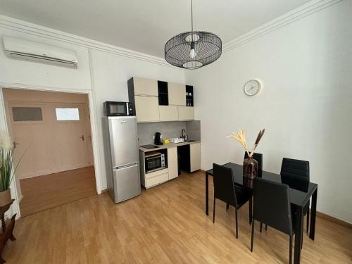 une cuisine et une salle à manger avec une table et des chaises dans l'établissement Appartement de charme proche stade Vélodrome, à Marseille