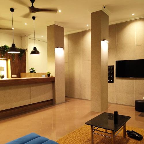 a living room with a blue couch and a table at Aurora Court Service Apartment in George Town