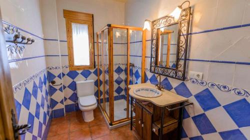 a blue and white bathroom with a toilet and a sink at La Chumbera Órgiva by Ruralidays in Órgiva
