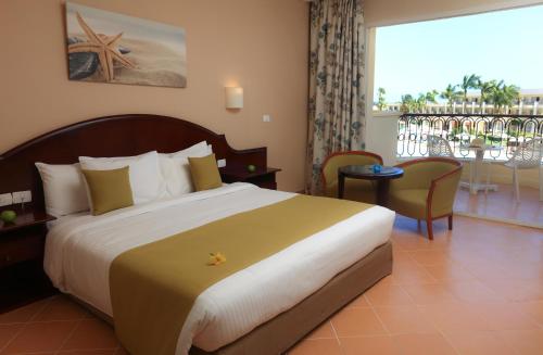 a hotel room with a large bed and a balcony at Labranda Royal Makadi in Hurghada