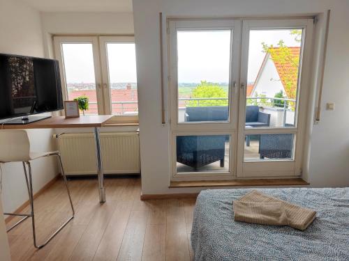 a bedroom with a desk with a computer and a window at Wohlfühlen im Studio nahe Messe und Airport in Leinfelden-Echterdingen