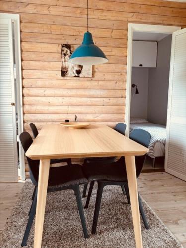 a wooden table with chairs and a blue light at Rödvattnet cottages in Rödvattnet