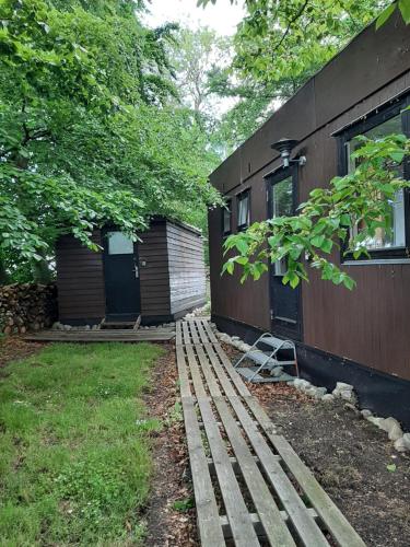 a house with a yard next to a building at Værelse i hytte ved stege nor in Stege