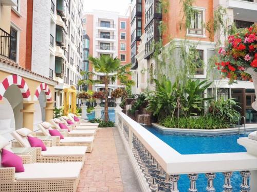 eine Hotelterrasse mit Stühlen und einem Swimmingpool in der Unterkunft Espana condo resort pattaya by Nongying in Jomtien Beach