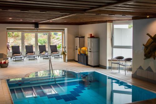 una piscina en una habitación con cocina y sillas en Hofer Stubn, en Kolsassberg