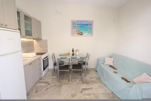 a living room with a table and a blue couch at Nikolas Marios by Frangki in Agia Marina Aegina