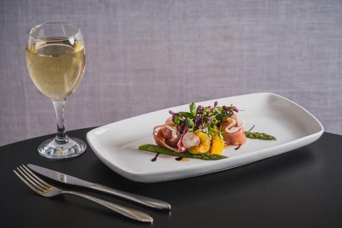 a plate of food next to a glass of wine at The Queens Hotel in Paignton