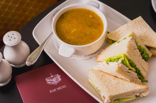a plate with a sandwich and a cup of soup at The Queens Hotel in Paignton