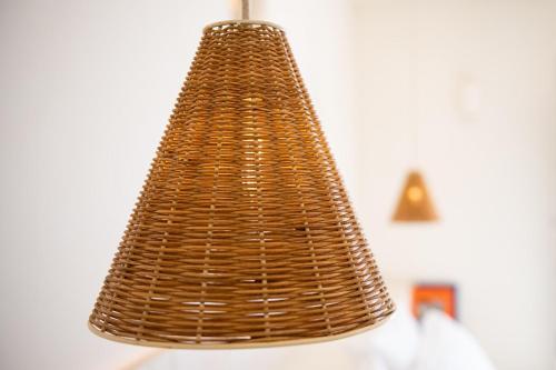 a brown wicker chandelier hanging from a wall at Porto Mykonos in Mýkonos City