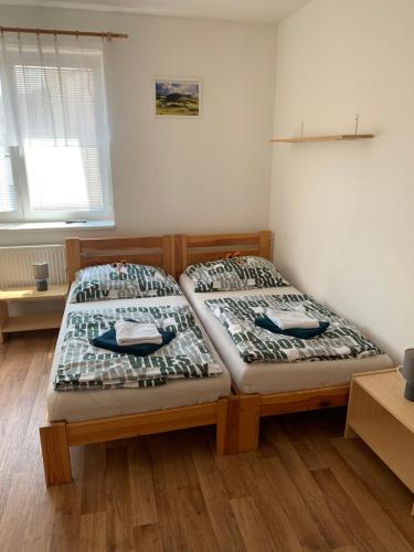 two twin beds in a room with wooden floors at Penzion Na Potoce in Ledeč nad Sázavou