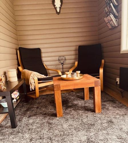 a living room with two chairs and a table at Rödvattnet cottages in Rödvattnet