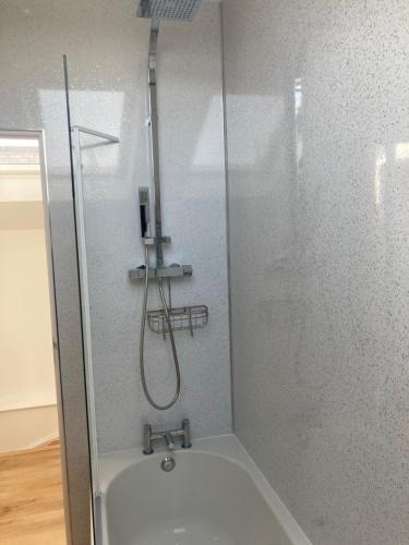 a shower in a bathroom with a tub at The Boathouse in Mylor Bridge