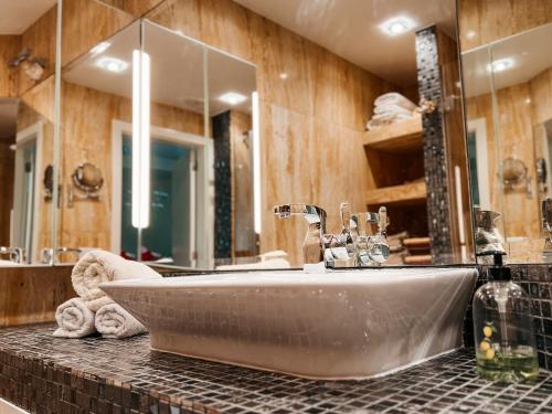 a bathroom with a sink and a large mirror at Cosy flat with sea view, pool and terrace in Altamira-complex in Costa Adeje - Playa del Duque in Adeje