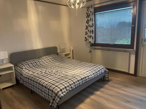 a bedroom with a bed with a plaid blanket and a window at Entire house for 5 person close to the beach in Bergkvara