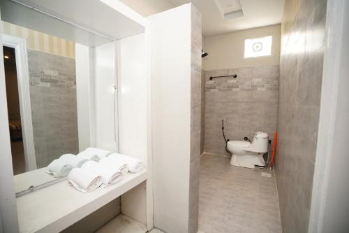 a bathroom with a toilet and a sink with towels at Green orchard skardu in Skardu