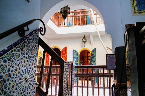 a staircase in a building with books on a shelf at Riad - In Medina - Kesh Design in Marrakesh