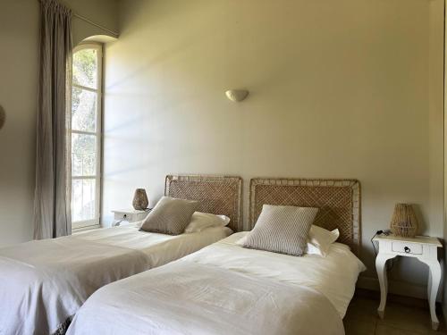 two beds sitting next to each other in a bedroom at Les figuiers in La Londe-les-Maures