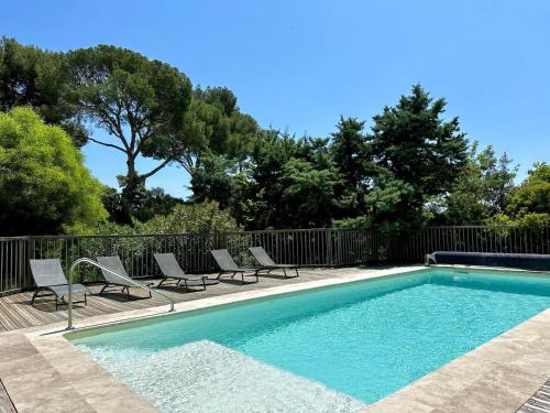 une piscine avec des chaises et une clôture dans l'établissement Les lauriers, à La Londe-les-Maures