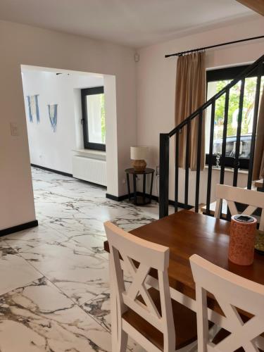 a living room with a wooden table and chairs at Apartamenty Zielona Dolina nr 4 in Szteklin