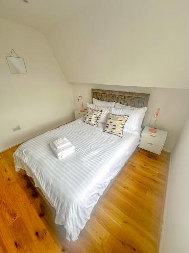 a bedroom with a large bed with white sheets and pillows at Maple Street Apartments in London
